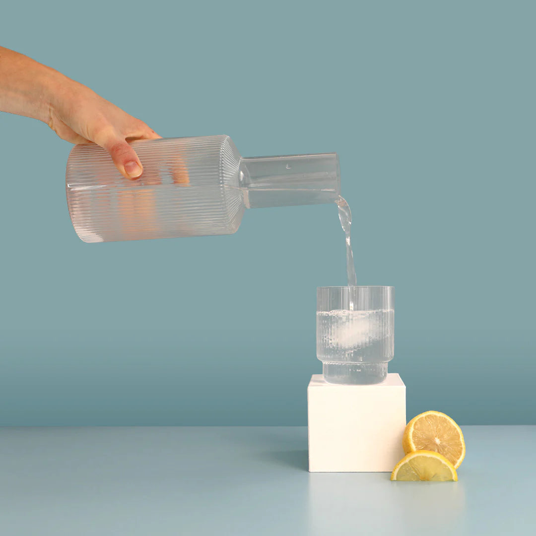lemonade hydramama being poured into glass with lemons sitting