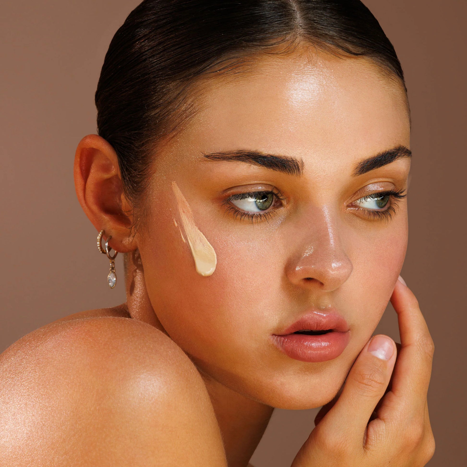 Light avo zinc Woman applying cream to her face with a neutral background