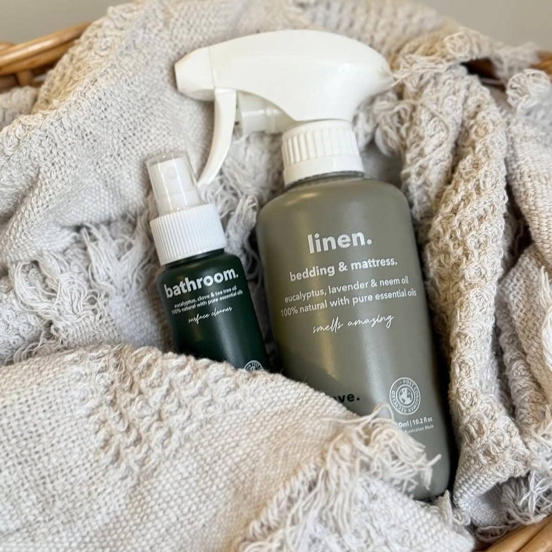 Two cleaning products, 'bathroom' and 'linen', on a textured fabric background.