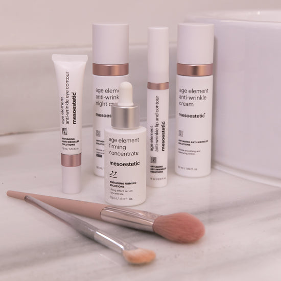 Mesoestetic skincare products with applicators on a white surface