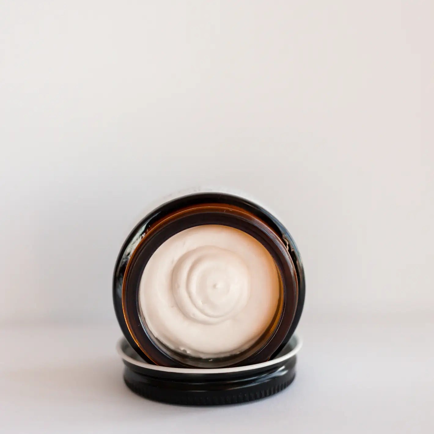 Nipple balm made simply natural Cosmetic cream in a black jar on a light gray background