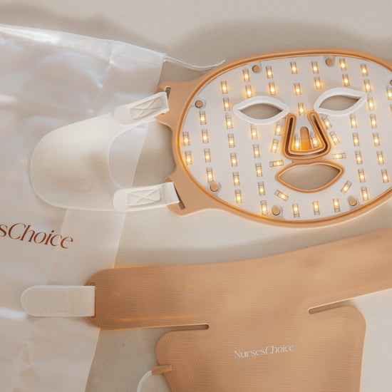 NursesChoice LED face therapy mask set with a white face mask, rose gold metal frame, dual charging pads, and a white drawstring bag on a light beige background.