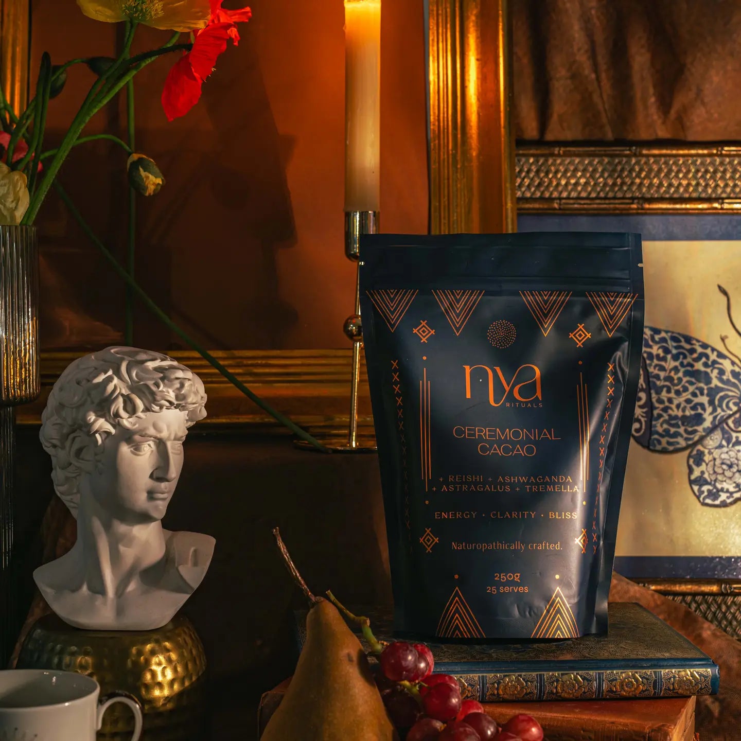 Nya Ceremonial Cacao package on a table with decorative items including a bust and flowers.