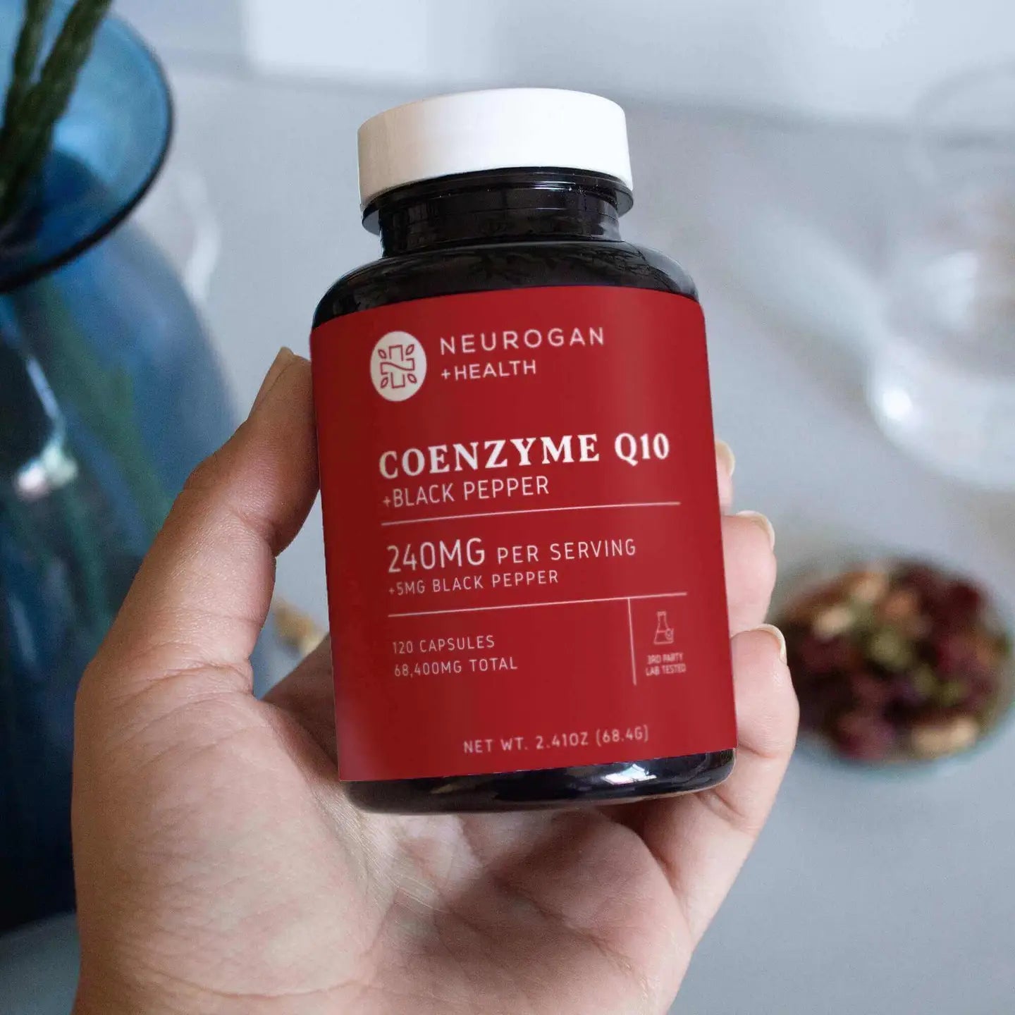 Neurogan Health Coenzyme Q10 supplement bottle held in a hand with a blurred background