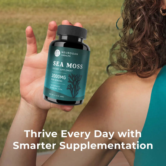 Person holding a bottle of Neurogan Health Sea Moss supplement with a grassy background