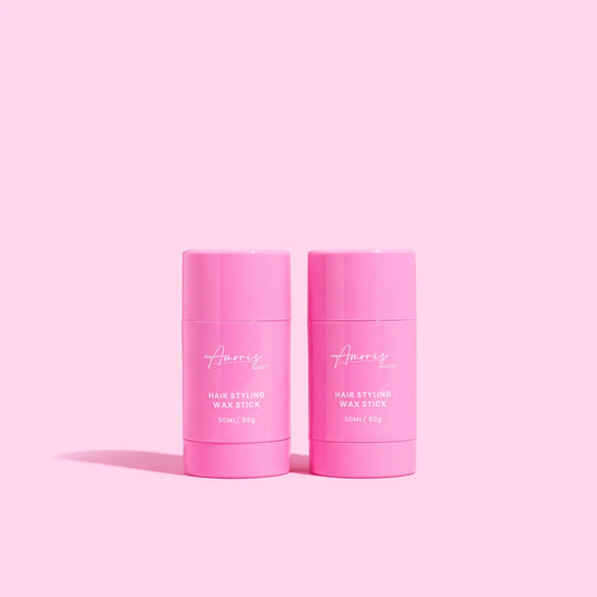 Two pink hair styling wax sticks on a pink background